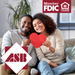 A young couple holding a red paper heart together