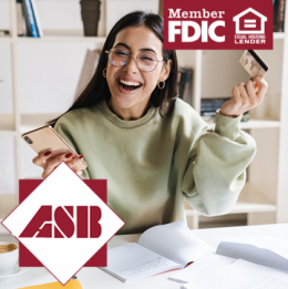 Woman smiling with her smartphone in one hand and a credit card in the other hand