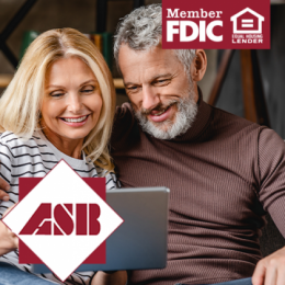 Older man and woman sitting together and smiling at a tablet