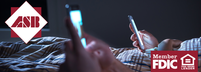 Two people lying in bed both on their phones
