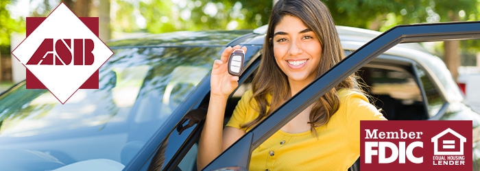 Woman holding up car keys and standing by car with door open