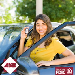 Woman holding up car keys and standing by car with door open