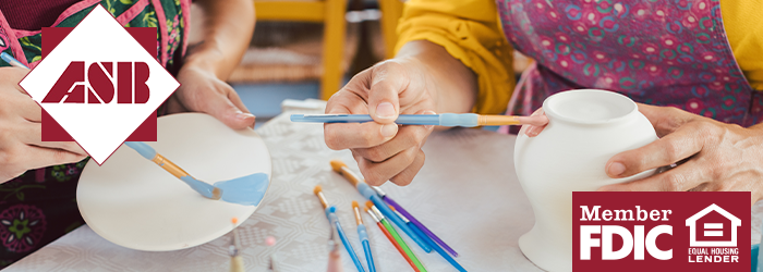 Two people painting a plate and vase